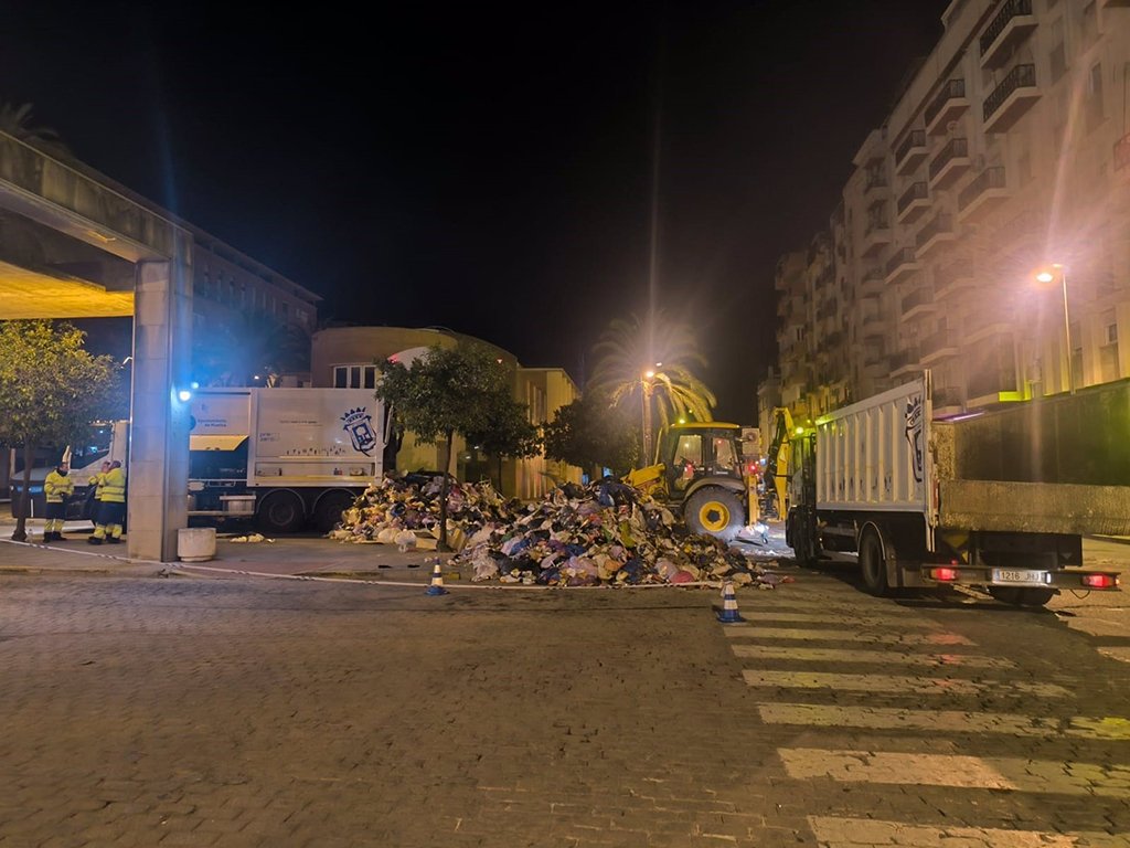 Un hombre cae a un camión de la basura desde un contenedor